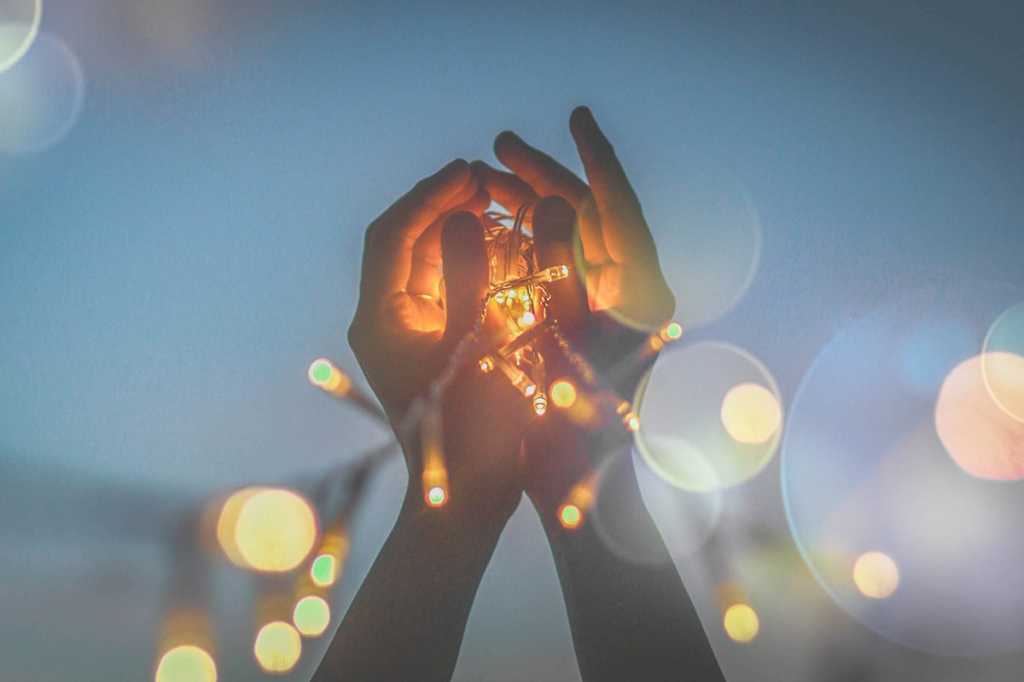 hands holding up a string of lights / ideas / innovation / brainstorming