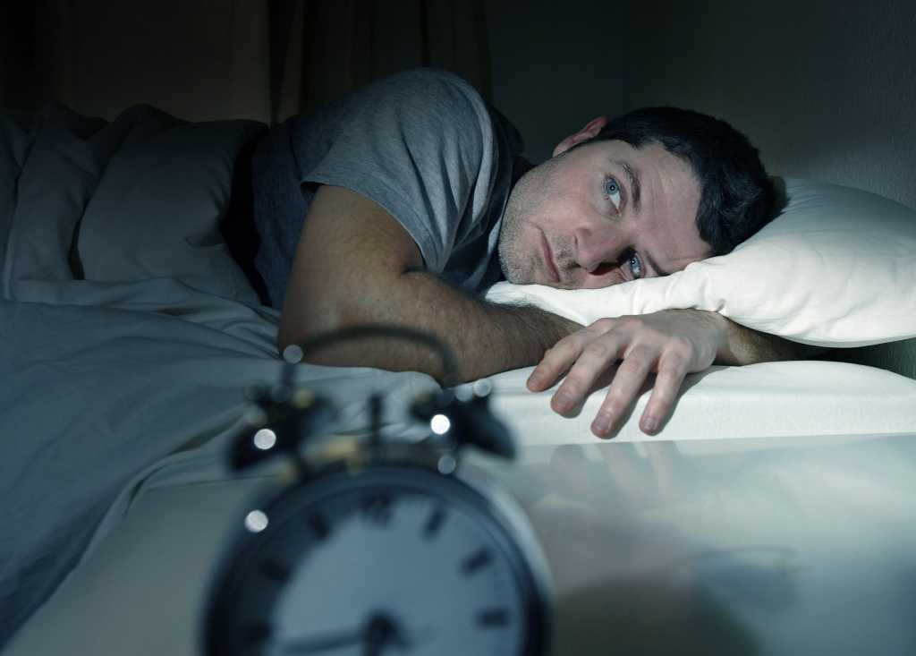 man in bed unable to sleep