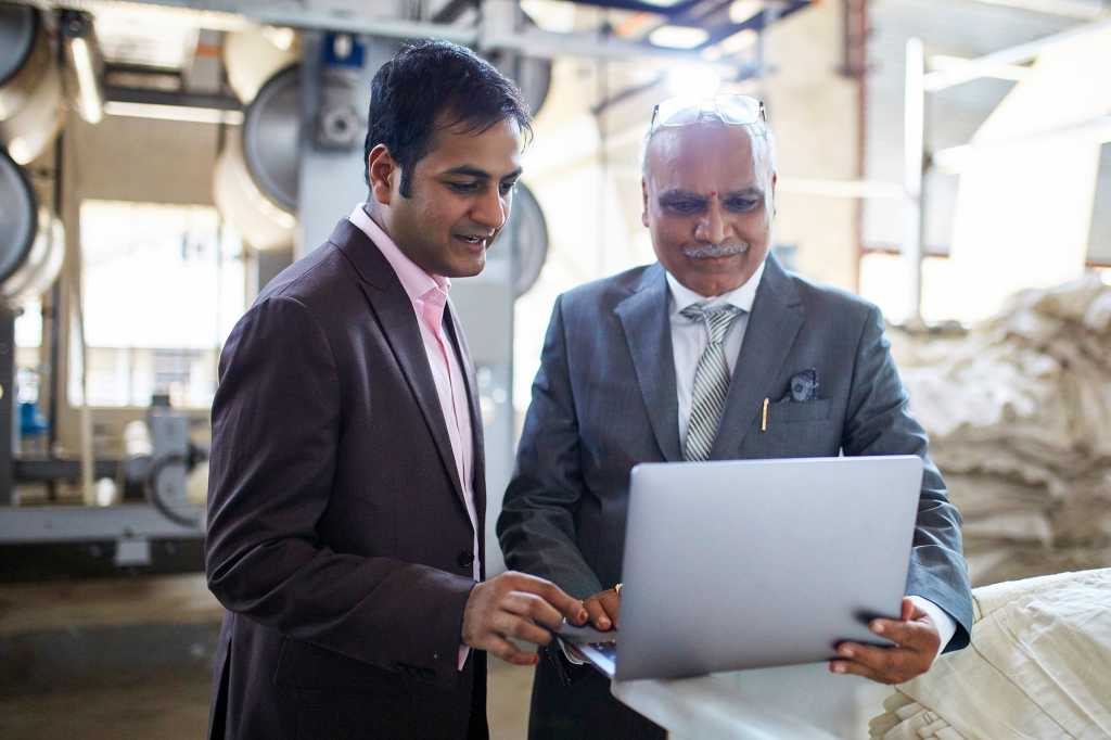 Industrial IoT / Operational Technology > Indian businessmen meet on a factory floor.
