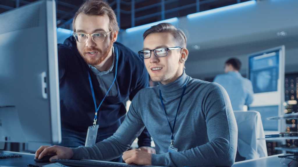 Der Techniker für Elektronikentwicklung verwendet persönliche Computergespräche mit dem Manager, zeigt Projektdetails an. Profi-Team verwenden Digital Whiteboard mit CAD-Software für modernes Industriedesign